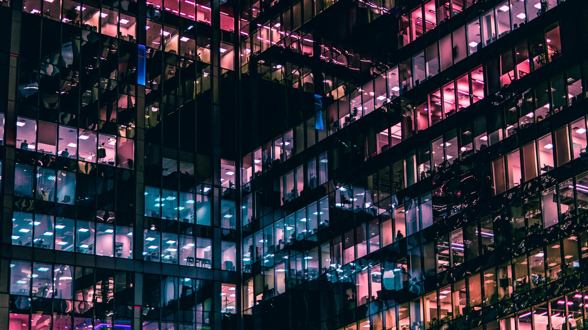Office tower windows lit at night, seen from outside