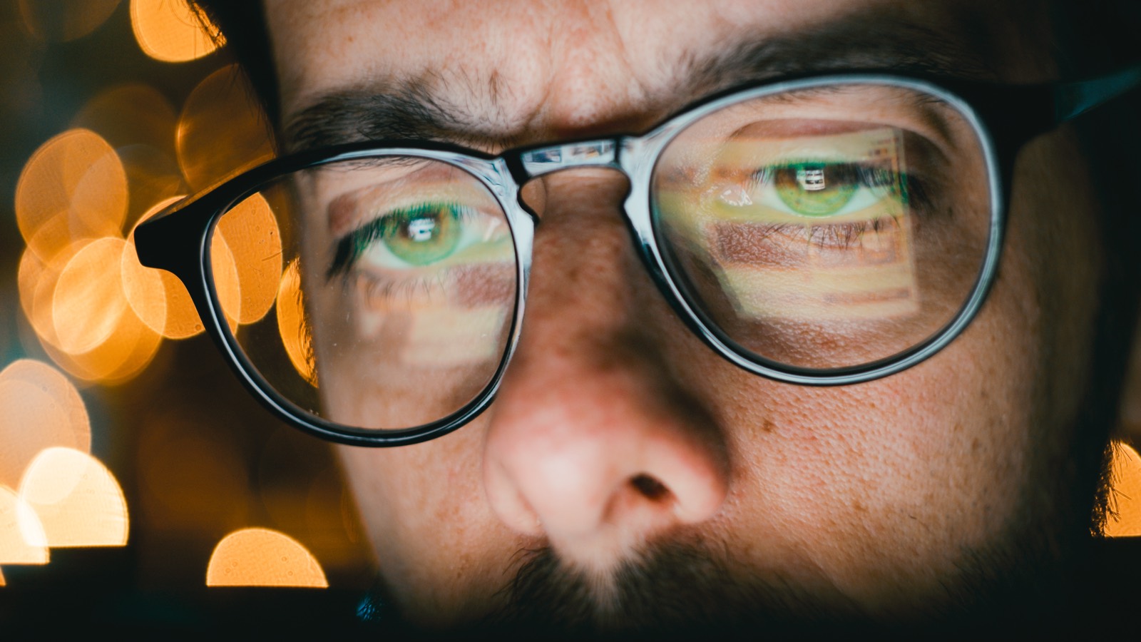 A person's glasses reflecting data from a screen